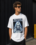 Person wearing a white t-shirt with an alien graphic and text against a black background